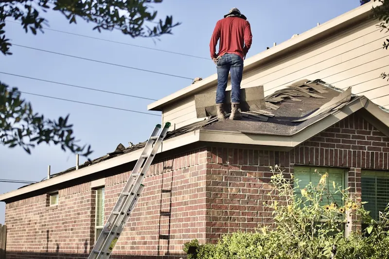 Professional roofer working on a residential roof in Jenners